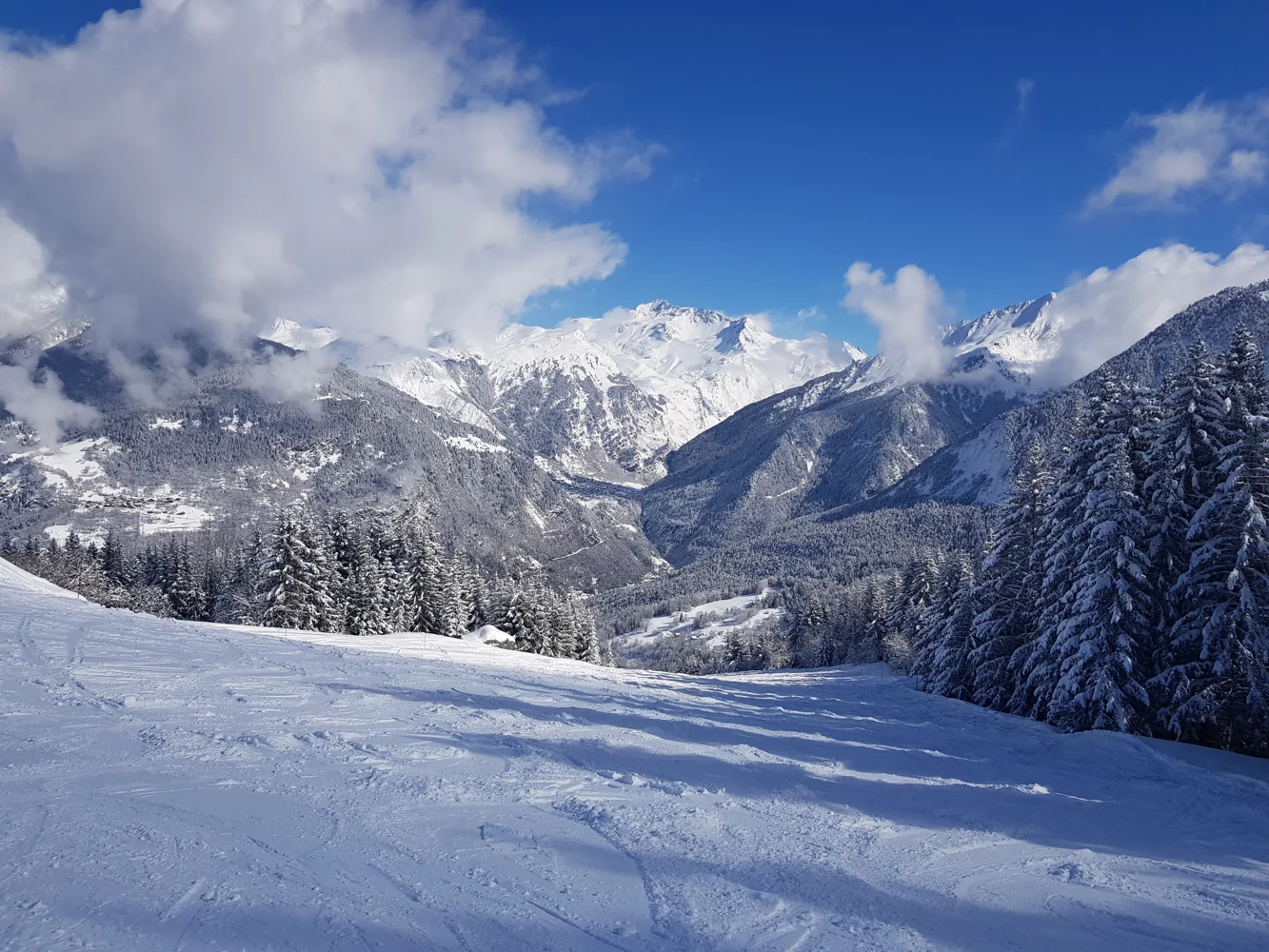 Sunshine over snowy trees and the Courchevel mountains